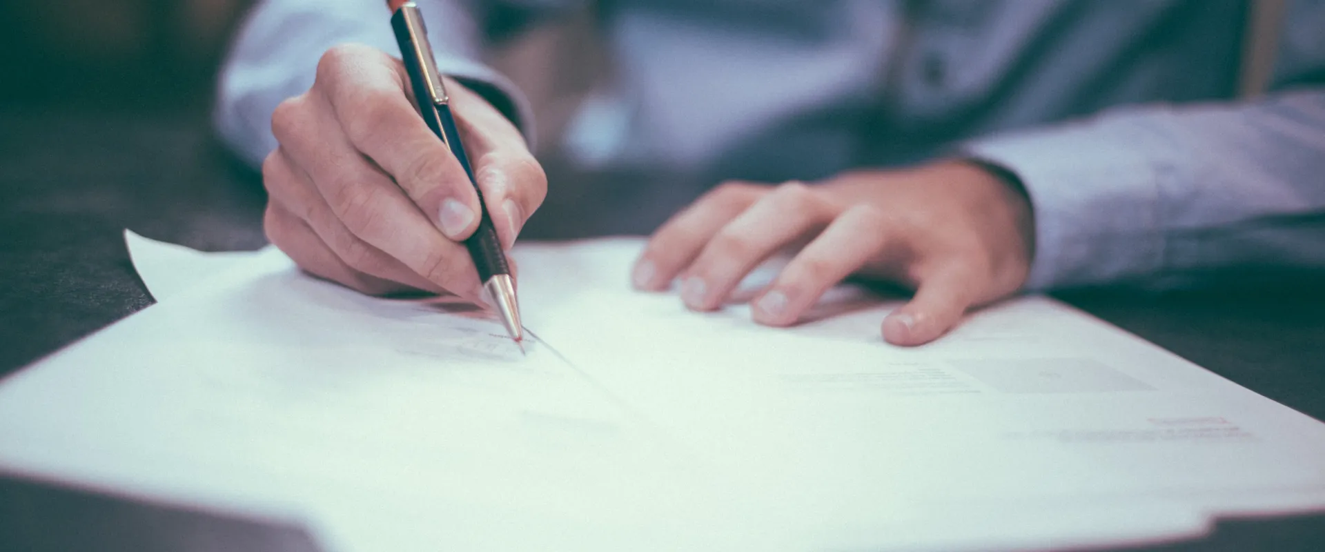 Personne rédigeant un texte assis à son bureau