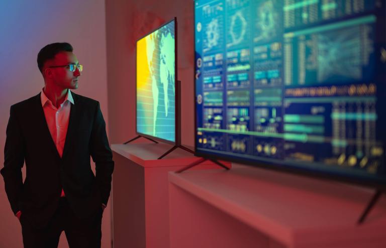 Trader devant un tableau présentant des indices boursiers